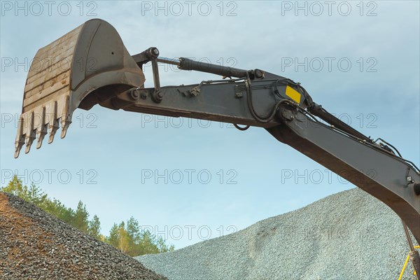 Shovel of the excavator on a background of sky