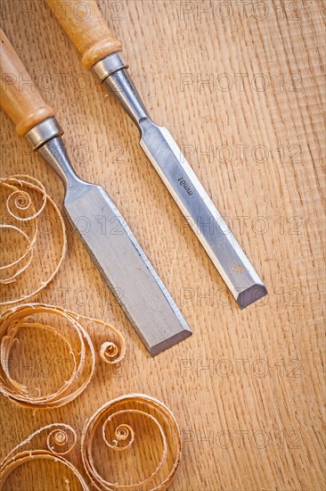 Carpenter's chisel on wooden board with wood shavings