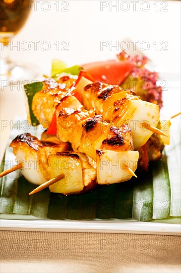 Fresh chicken and vegetables skewers on a palm leaf thai style