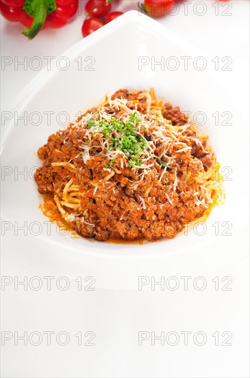 Italian classic spaghetti with bolognese sauce and fresh vegetables on background