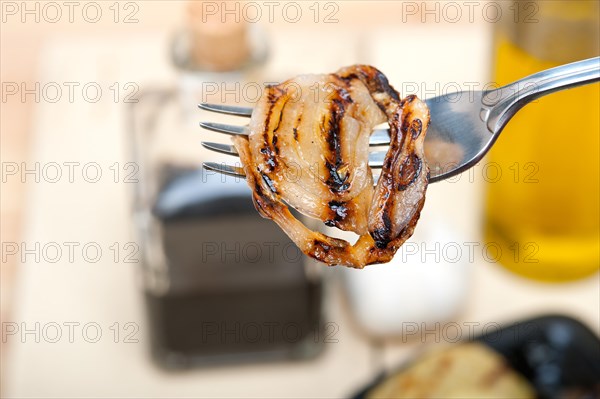 Grilled onion on a fork macro close up