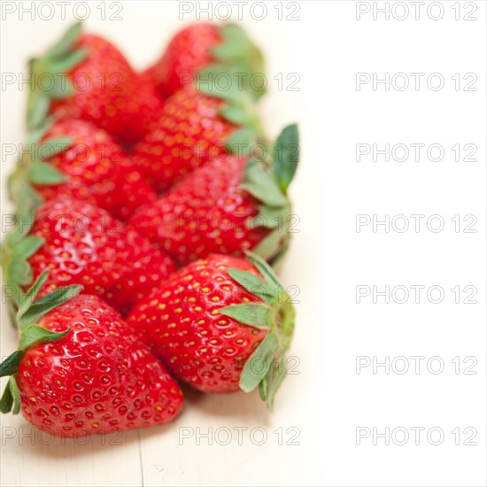 Fresh organic strawberry over white rustic wood table