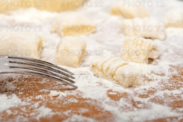 Making fresh Italian potato gnocchi on a wood rustic table