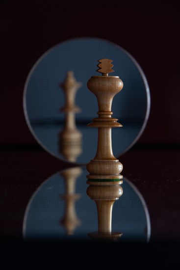 Reflection of a queen chess piece in a mirror