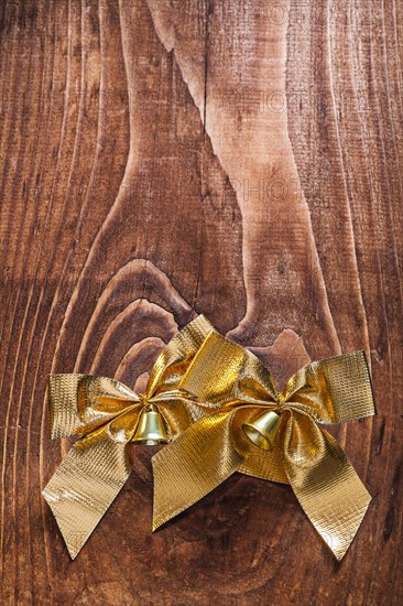 Golden bows on wooden board with copying surface