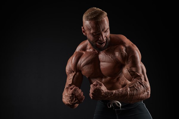 Handsome strong athletic men pumping up muscles. Workout