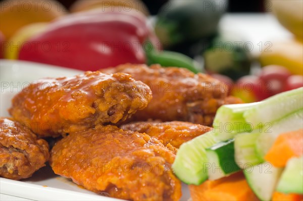 Classic buffalo chicken wings served with fresh pinzimonio and vegetables on background