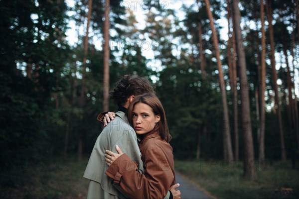 Romantic couple of lovers on a date in the park in cold weather. Fashionable couple in coat