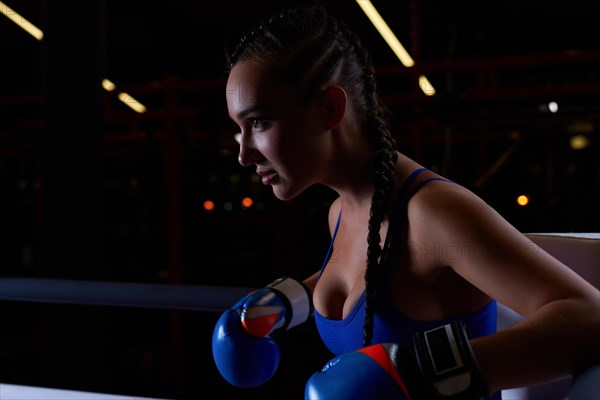 Powerful charged girl stands in the corner of the ring and is ready to explode in the next round. The concept of wrestling and boxing. Mixed media