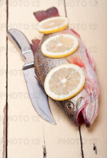 Fresh whole raw fish on a wooden table ready to cook