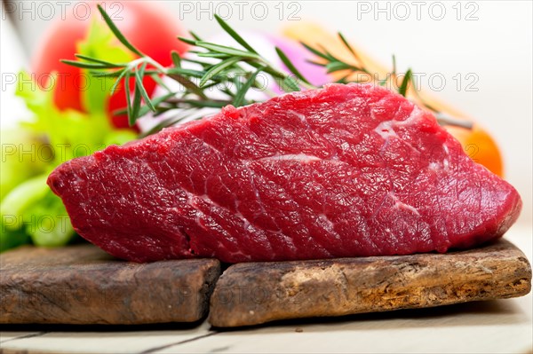 Fresh raw beef cut ready to cook with vegetables and herbs