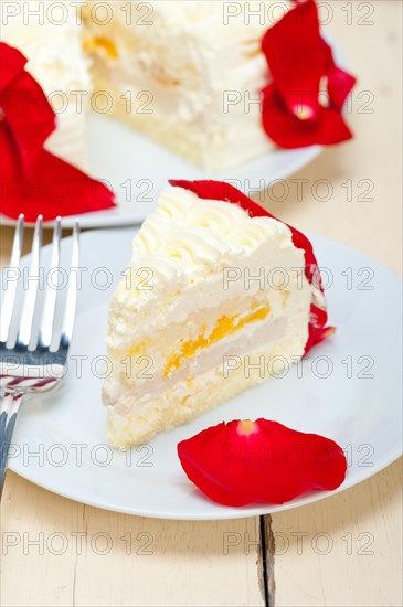 Whipped cream mango cake with red rose petals