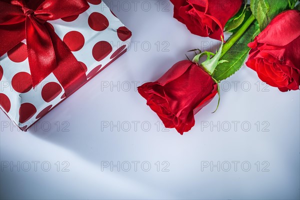 Present box red roses on white background