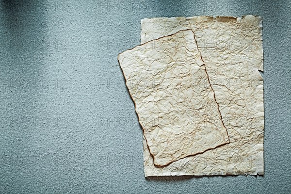 Ancient crumpled manuscripts on grey surface