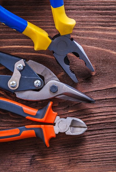 Pliers pliers and wire cutters on vintage brown wooden board construction concept