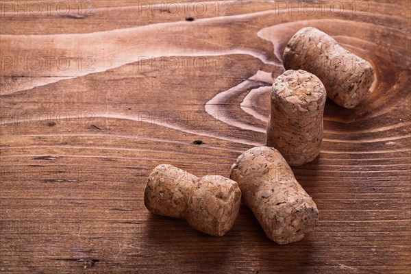 Four corks of champagne on vintage wooden board alcohol concept