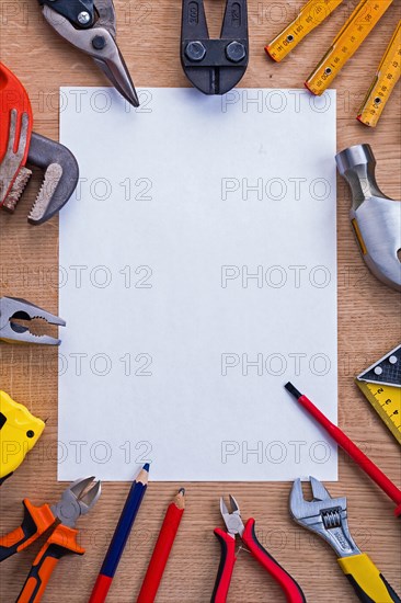 Organised copying surface white paper and cutter metre hammer roller screwdriver pliers pencil tapeline spanner on wooden board