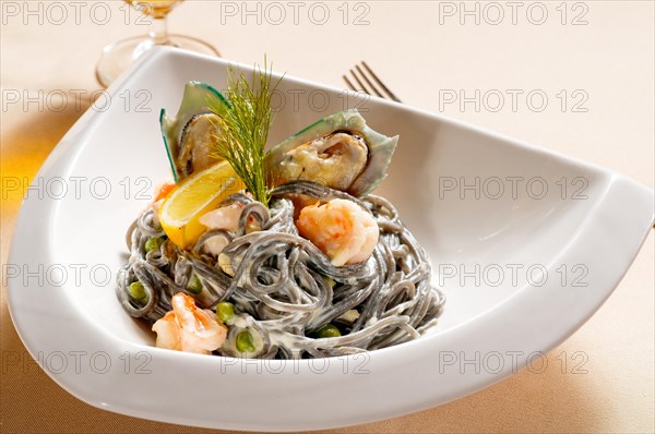 Fresh seafood black squid ink coulored spaghetti pasta tipycal italian food