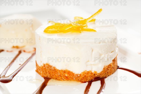 Very elegant lemon mousse dessert served whith lemon peel on top and vanilla ice cream on side