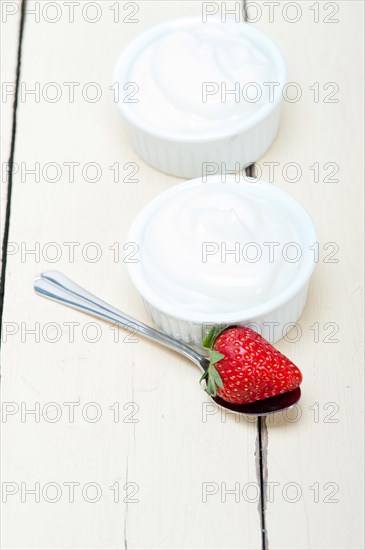 Organic Greek yogurt and strawberry over white rustic wood table