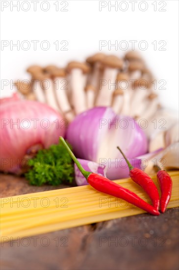 Italian pasta and mushroom sauce raw ingredients over rustic old wood