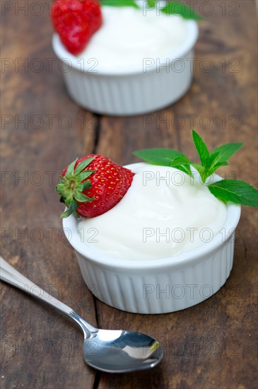 Organic Greek yogurt and strawberry on a rustic wood table