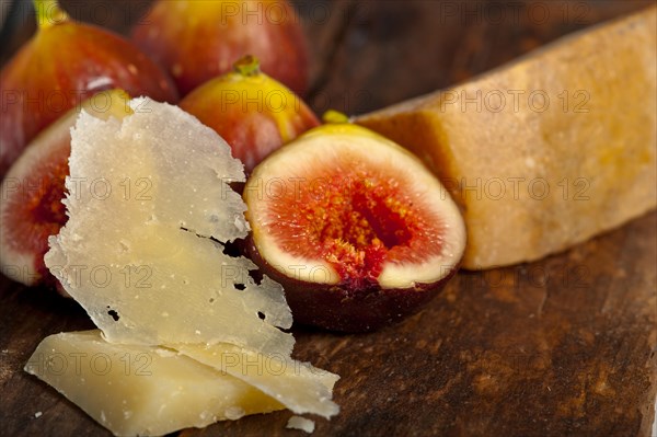 Italian pecorino cheese and fresh figs macro closeup over old wood boards