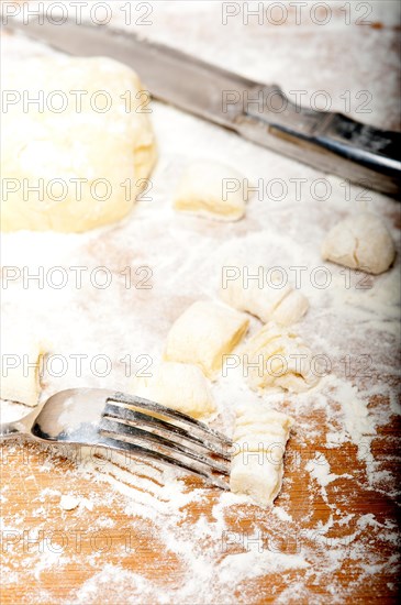 Making fresh Italian potato gnocchi on a wood rustic table