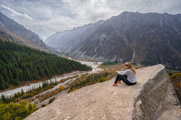 Hiker enjoying the view of the Ala Archa valley from the viewpoint at broken heart rock