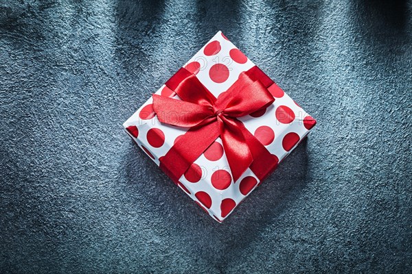 Boxed present with tied bow on black background holidays concept