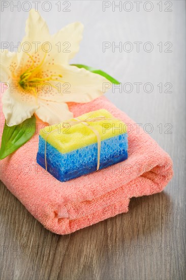 Bath sponge soap and flower on towel