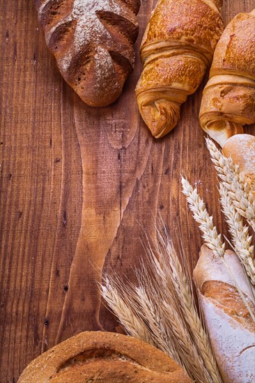 Bread with ears on a wooden background Food and drink Still life