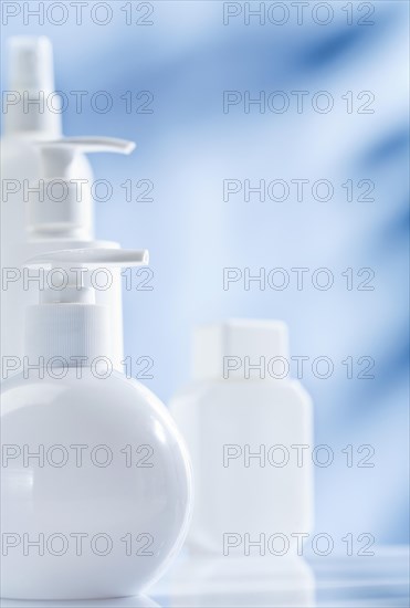 Composition of white skin care products on a blue background