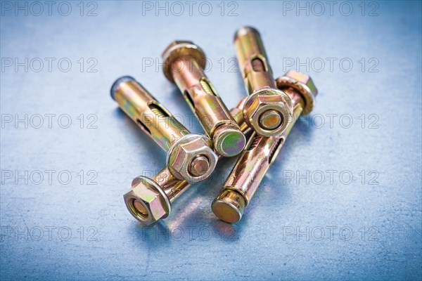 Metallic anchor bolts for concrete walls on a metallic background Repair concept