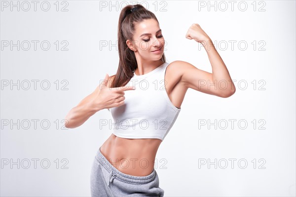 Young white fitness woman wearing sportswear standing over white wall background. Fitness concept. Mixed media