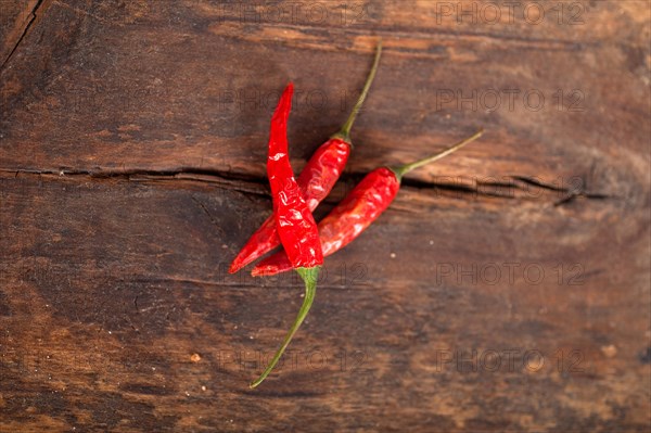 Dry red chili peppers over old wood table