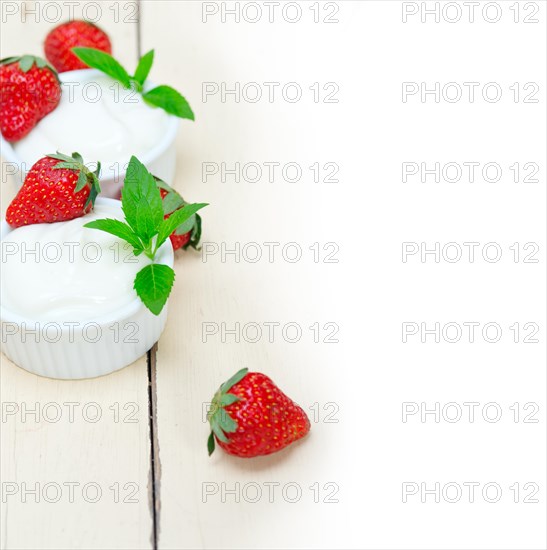 Organic Greek yogurt and strawberry over white rustic wood table