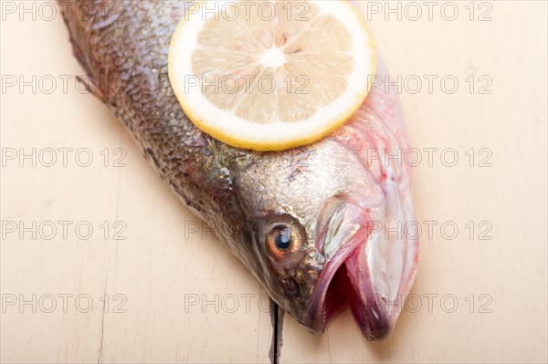 Fresh whole raw fish on a wooden table ready to cook