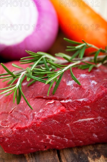 Fresh raw beef cut ready to cook with vegetables and herbs