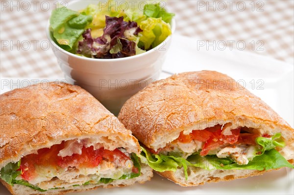 Italian ciabatta panini sandwich with chicken and tomato