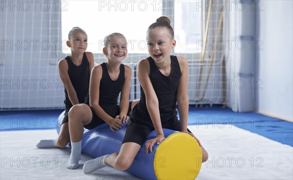 Image of a group of little girls in the gym after a workout. Gymnastics concept. Mixed media