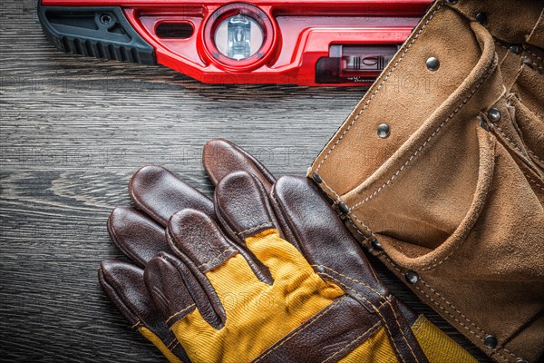 Construction level safety gloves leather tool belt on wood board