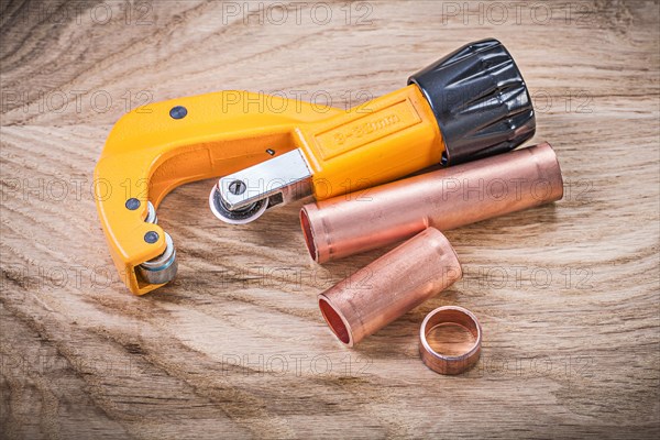 Horizontal image of brass water pipe cutter on wooden board plumbing concept