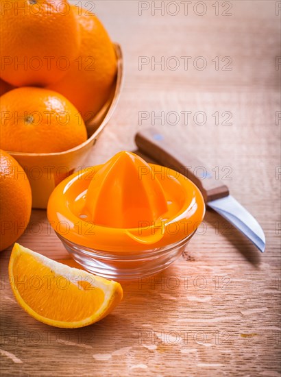 Orange squeezer and fruit knife on wooden table