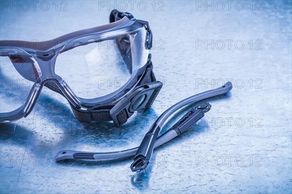 Plastic safety spectacles on a metallic background Design concept