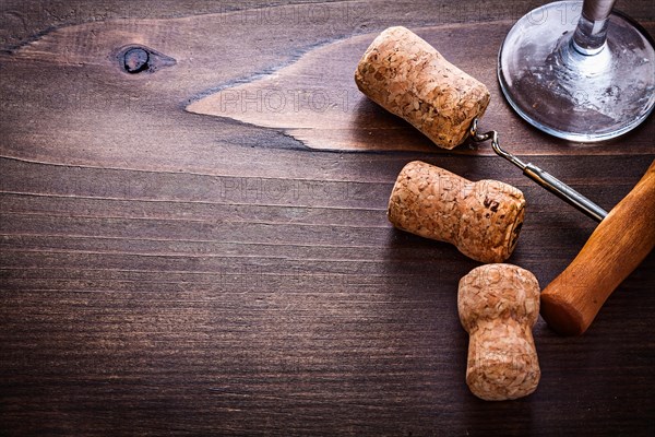 Champagne corks and corkscrew on vintage wooden board with copying area