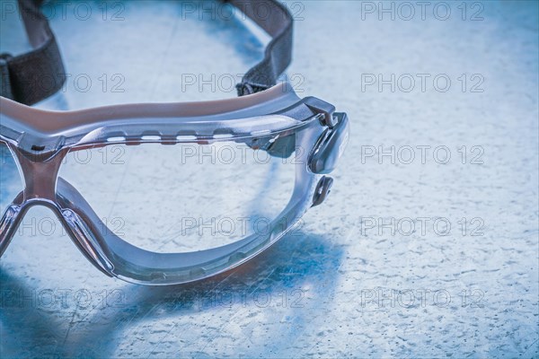 Plastic safety spectacles on a metallic background Design concept