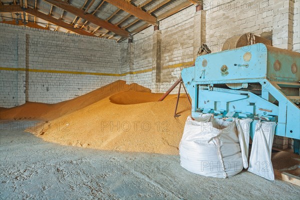 Grain dryer and stacks of wheat grains in an old warehouse