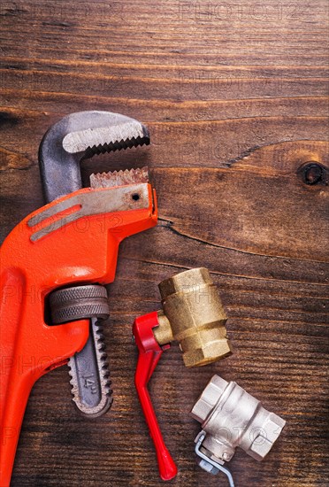 Plumbing fittings and monkey spanner on vintage wooden board