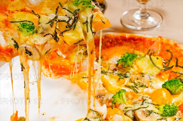 Fresh italian thin style vegetarian pizza with fresh mixed vegetables close up
